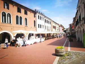 una strada con tavoli e ombrelloni in una città di Hotel Aurora a Mestre