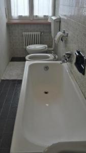 a bathroom with a white toilet and a bath tub at Albergo Ristorante Pizzeria Bellavista in Carenno