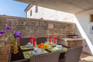 a table with food and fruit on a patio at kuća Maja in Štokovci