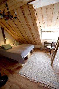 ein Schlafzimmer mit einem großen Bett in einer Holzdecke in der Unterkunft Metsara B & B in Tornimäe