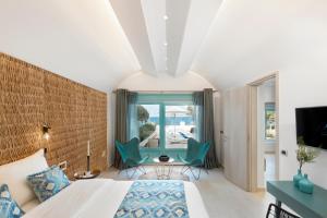 a bedroom with a bed and a table and chairs at Almyriki Beach Villa in Monolithos +51 photos