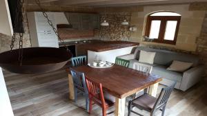 uma cozinha e sala de jantar com uma mesa e uma banheira em Trullo in Uliveto by RENTHOUSESALENTO em San Foca