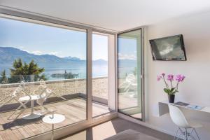 a room with a balcony with a view of the ocean at Hotel Lavaux in Cully