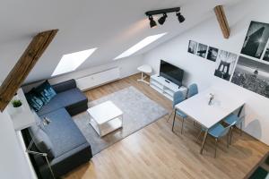 vistas panorámicas a una sala de estar con sofá y mesa en Pytloun Apartments Liberec, en Liberec