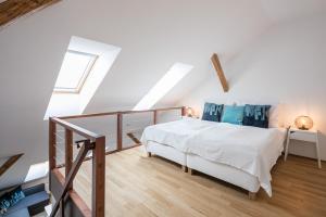 1 dormitorio con cama blanca y suelo de madera en Pytloun Apartments Liberec, en Liberec