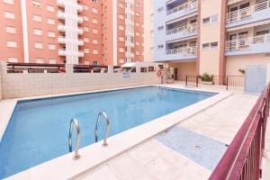 - une piscine dans un bâtiment avec des bâtiments dans l'établissement Apartamentos Marblau Peredamar-Julio y Agosto SOLO FAMILIAS, à Gandía