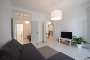 a living room with a couch and a flat screen tv at Maria's 5th Avenue in Setúbal
