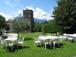 een groep tafels en stoelen in het gras bij Hotel Toresela Bike am Gardasee in Nago-Torbole
