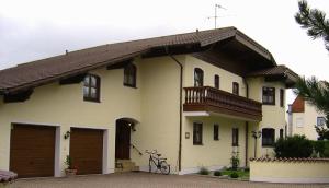 Una casa blanca con un balcón encima. en Appartementhaus Moser, en Bad Füssing