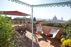 een patio met een tafel en stoelen onder een parasol bij Antica Dimora Johlea in Florence