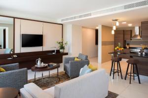 Fraser Suites Muscat في مسقط: غرفة معيشة مع أريكة وطاولة