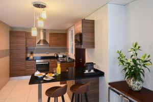 a kitchen with a black counter and wooden cabinets at Fraser Suites Muscat in Muscat