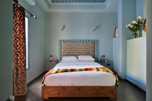 a bedroom with a large bed with a wooden headboard at Riad Goloboy in Marrakech +70 photos