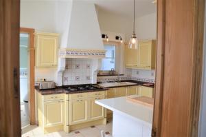 eine Küche mit gelben Schränken und einer weißen Arbeitsplatte in der Unterkunft Ciepers Lodge in Ypern