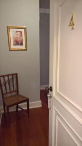 a door with a chair and a picture on the wall at Quinta do Cabo Guesthouse in Sintra