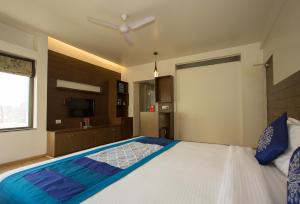 a bedroom with a large bed with a ceiling fan at Corporate Stay in Pune