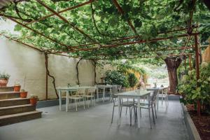 eine Terrasse mit Tischen und Stühlen unter einer Pergola in der Unterkunft Anemi Beach in Skala Potamias