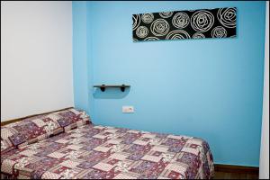 コニル・デ・ラ・フロンテーラにあるApartamento Baluarte IIIの青い壁のベッドルーム1室(ベッド1台付)