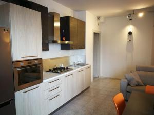 a kitchen with white cabinets and a stove top oven at Cabà Holiday Bardolino Gritti in Bardolino