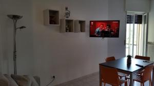 a living room with a table and a tv on a wall at Cabà Holiday Bardolino Gritti in Bardolino