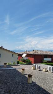 a gravel parking lot with benches in front of buildings at Cabà Holiday Bardolino Gritti in Bardolino