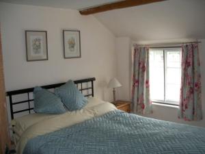 1 dormitorio con cama y ventana en Shipwrights Cottage, en Salcombe
