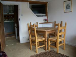 una mesa de madera y 4 sillas en una habitación en Shipwrights Cottage, en Salcombe