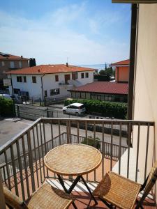 a table and chairs on a balcony with a car at Cabà Holiday Bardolino Gritti in Bardolino