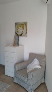 a living room with a chair and a flower painting at Cabà Holiday Bardolino Gritti in Bardolino