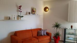 a living room with an orange couch and a shelf at Cabà Holiday Bardolino Gritti in Bardolino