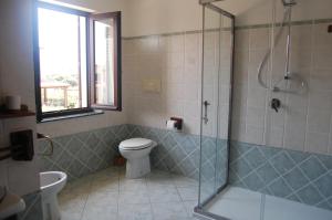 a bathroom with a toilet and a glass shower at I Ginepri B&B in Portoscuso