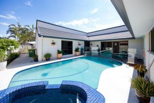 a large swimming pool in front of a house at Gold Coast Mermaid Waters Duplex House in Gold Coast