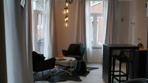 sala de estar con sillas, mesa y ventanas en PortaNova 21 en Huy
