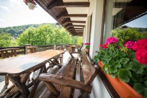 een rij houten tafels en stoelen op een balkon met bloemen bij Bran Chalet in Bran