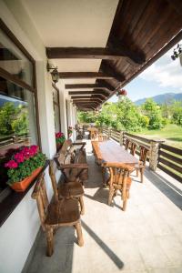 a patio with wooden tables and chairs and flowers at Bran Chalet in Bran