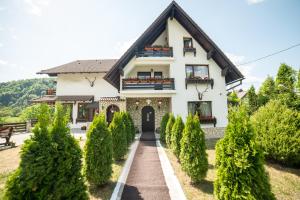 a white house with a black roof at Bran Chalet in Bran
