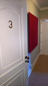 um quarto com uma porta branca com uma parede vermelha em Quinta do Cabo Guesthouse em Sintra