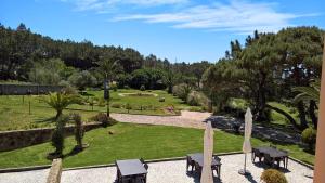 a park with tables and chairs and a park with trees at Quinta do Cabo Guesthouse in Sintra
