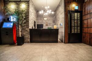 a lobby with a reception desk and a brick wall at Hotel Stay 53 in Gwangju