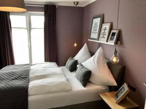 um quarto com uma cama com almofadas e uma janela em Boutique Hotel Lindenhof, Bed & Breakfast em Aurich