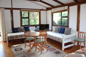 a living room with a couch and a table at Treehouse Cottage in The Crags