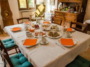 科斯蒂尤勒迪亞斯迪的住宿－Bed and Breakfast Cascina Beccaris，一张桌子上放着食物和橙色餐巾
