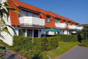 a building with an orange roof with bushes and an umbrella at Grothenns Hotel 3-Sterne superior in Bremen