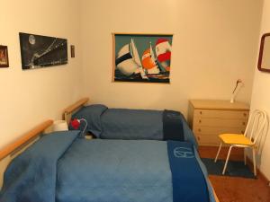 - une chambre avec un lit bleu et un bureau dans l'établissement Villa Gisira, à Augusta