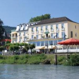 a large building with an umbrella next to a river at Hotel Rhein-Residenz in Bad Breisig