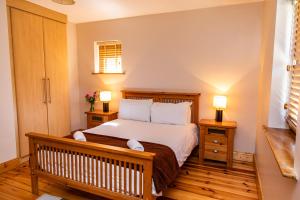 um quarto com uma cama com duas mesas de cabeceira e dois candeeiros em Piper's Chair Houses em Doolin