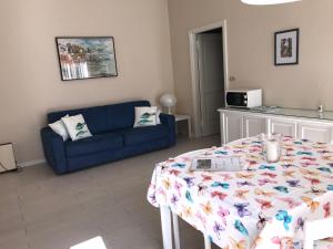 a living room with a table and a blue couch at Residence Le Logge in Torri del Benaco