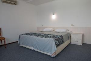 1 dormitorio con cama, mesita de noche y cama sidx sidx sidx sidx sidx en Alpatievo Hotel, en Alpat'yevo