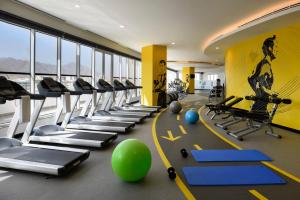 a gym with a bunch of treadmills and exercise equipment at Fraser Suites Muscat in Muscat