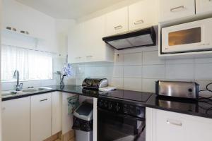 a kitchen with a black counter top and a microwave at Chakas Cove 94 in Ballito